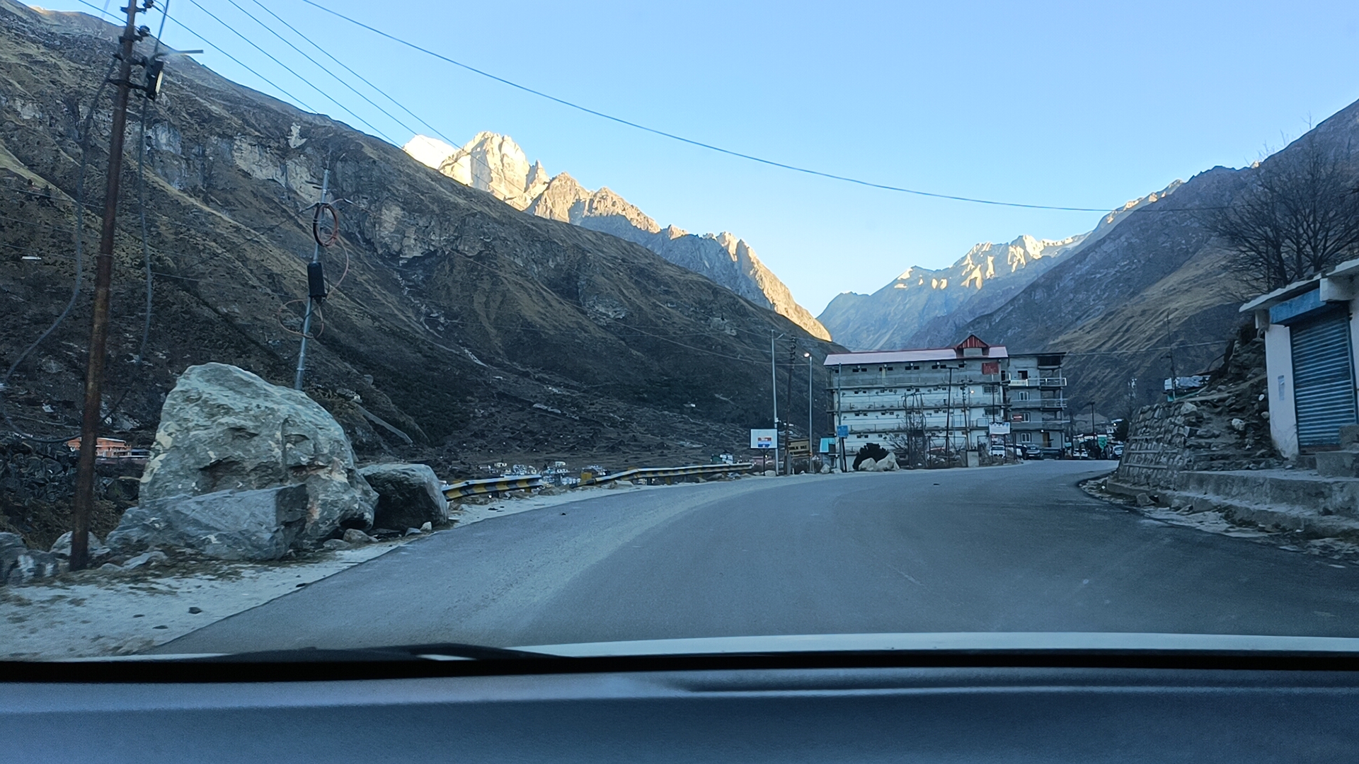 बद्रीनाथ मार्ग पर पहाड़ी सड़क और दूर हिमालयी चोटियां