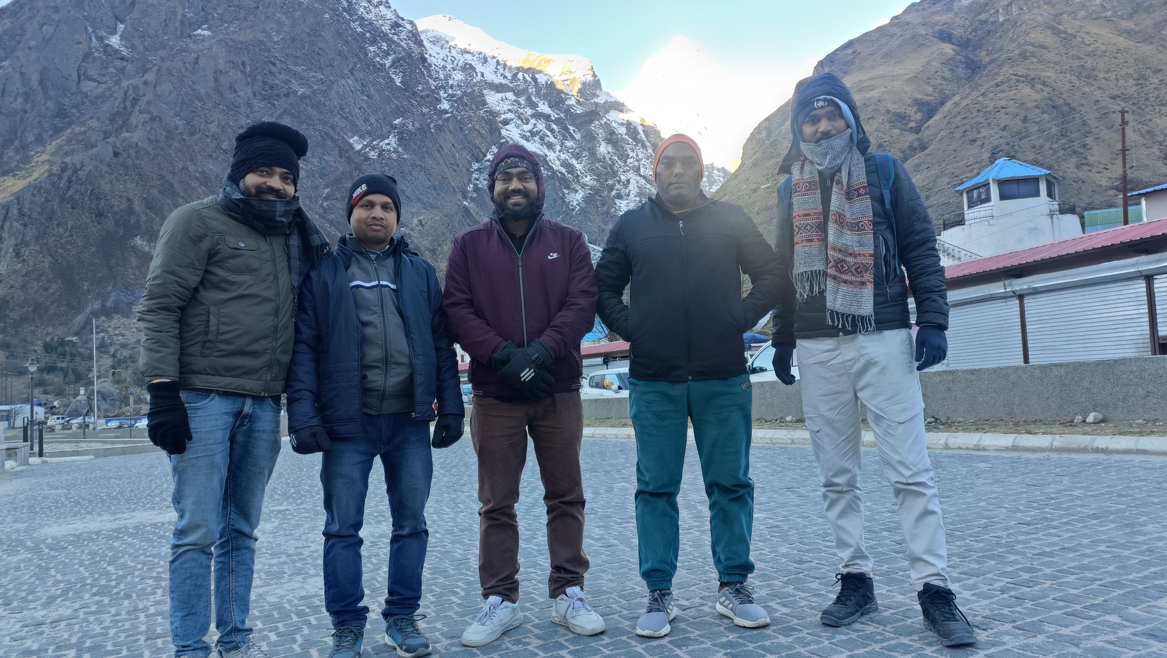 बद्रीनाथ में पहाड़ों के सामने साथियों की समूह तस्वीर