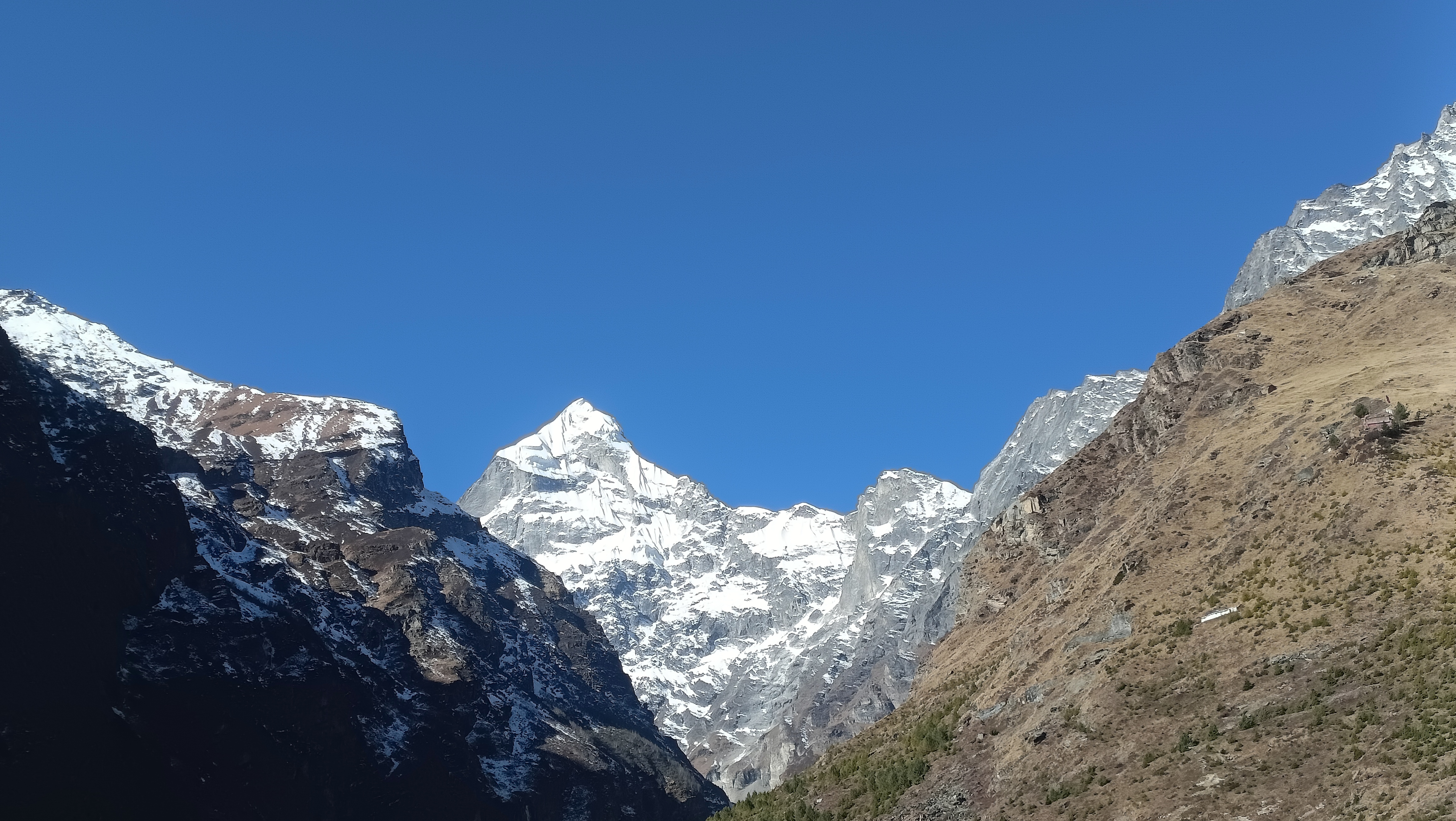 माणा गांव के रास्ते में बर्फ से ढकी हिमालयी चोटियां