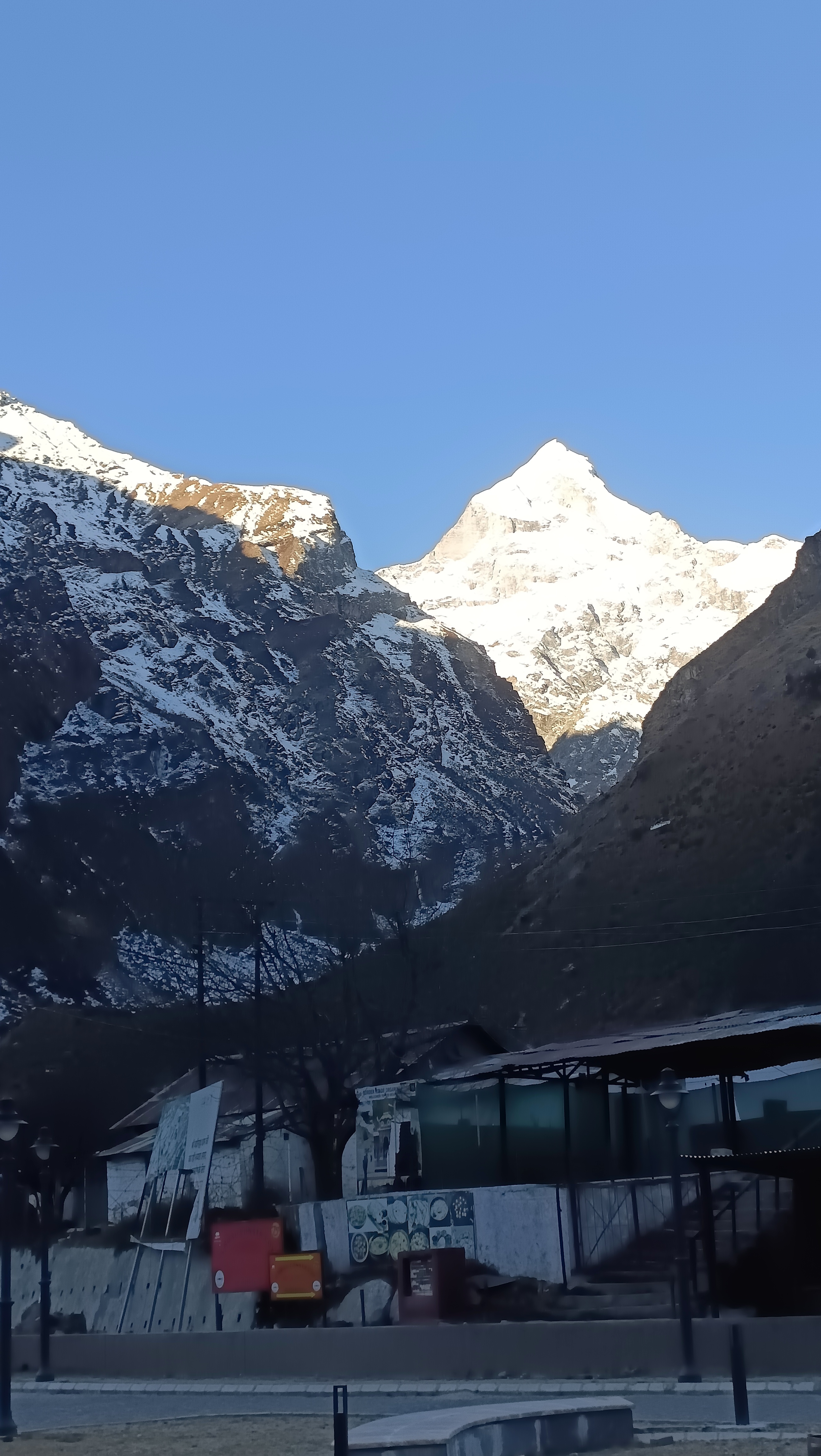 नीले आकाश के नीचे बर्फ से ढकी हिमालयी चोटी